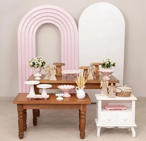 Set con arco rosa, mesa de madera y angelitos