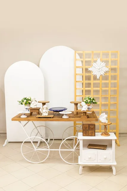 Set con arcos blancos, carrito de madera y celosía