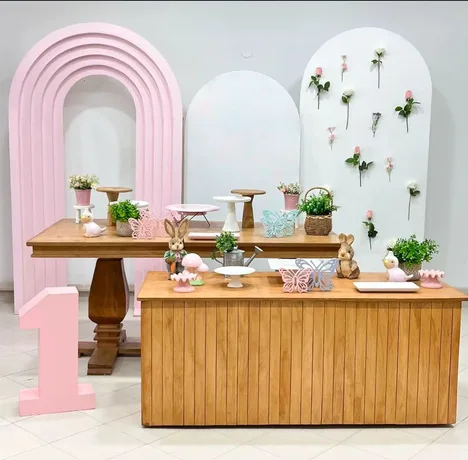 Set con arco rosa, número decorativo y mesa de madera