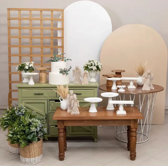 Set con cómoda verde salvia, arcos y mesa de madera